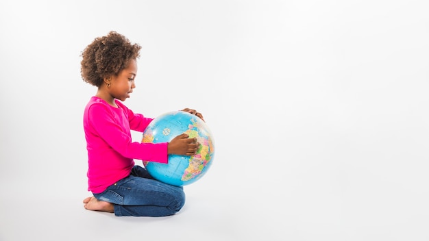 Foto meisje met globe in studio