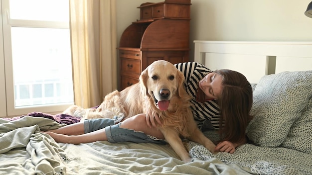 Meisje met golden retrieverhond in bed