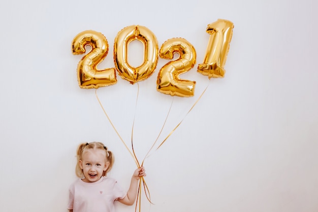 Meisje met gouden ballonnen met gouden cijfers