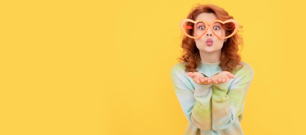 Meisje met grappige feestbril gelukkige roodharige vrouw draagt grappige feestbril stuur kus op gele achtergrond met plezier Vrouw geïsoleerd gezicht portret banner met kopie ruimte