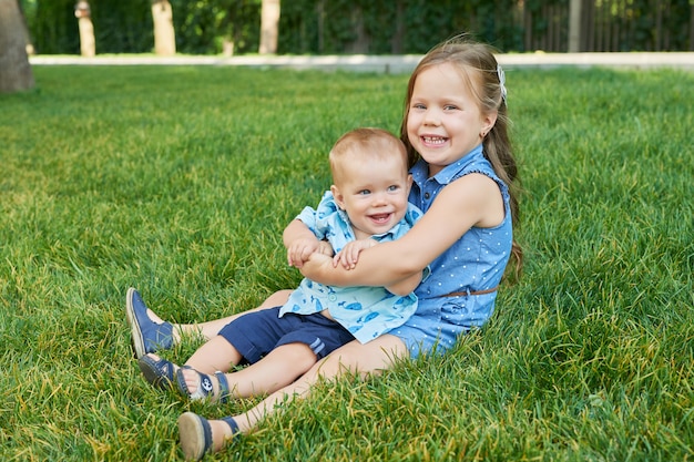 meisje met haar broer in een park op het gras