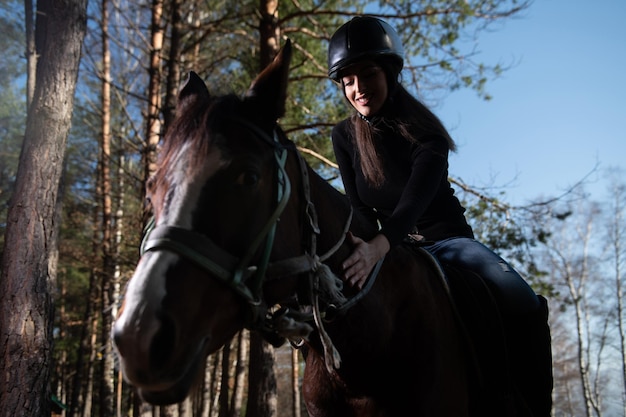 Meisje met helm op een paard in het bos