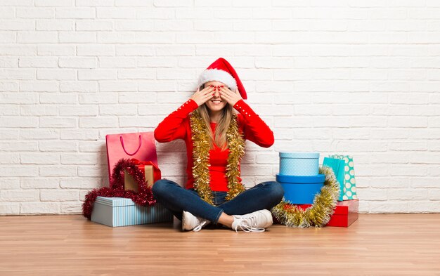 Meisje met Kerstmishoed en vele giften die de Kerstmisvakantie vieren die ogen behandelen