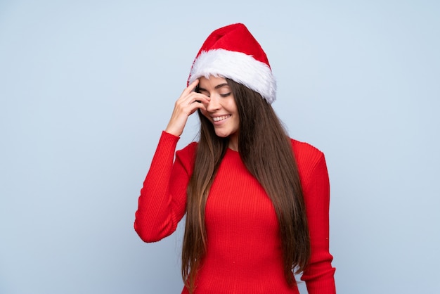 Meisje met Kerstmishoed over het geïsoleerde blauwe lachen