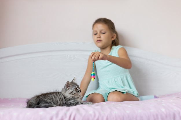 Meisje met klein katje in de kamer