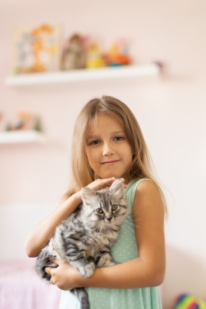 Meisje met klein katje in de kamer