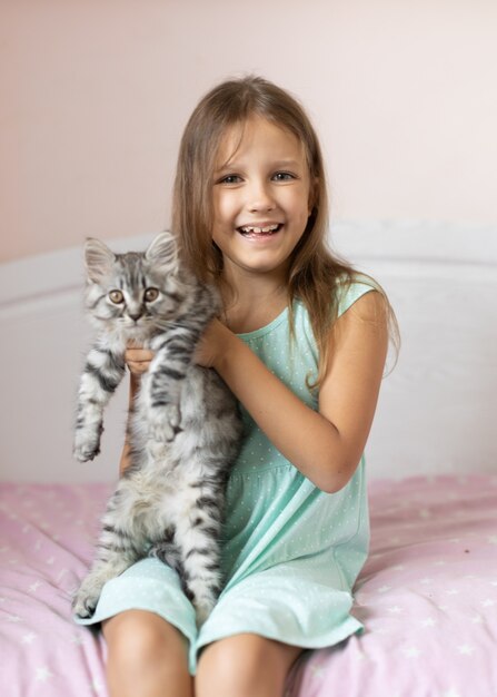 Meisje met klein katje in de kamer