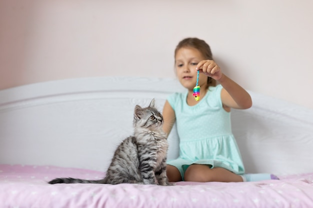 Meisje met klein katje in de kamer