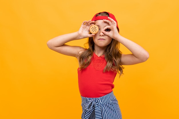 Meisje met koekjes op een gele geïsoleerde achtergrond