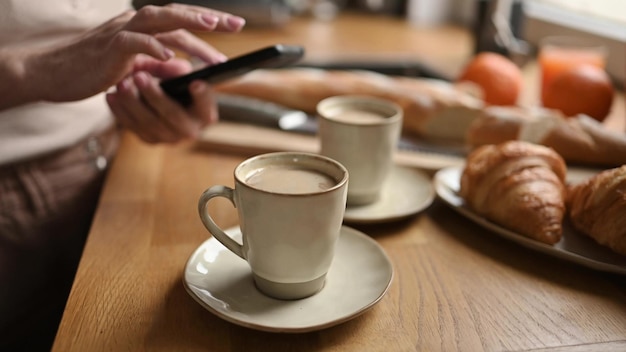 Meisje met koffiecappuccino en smartphone