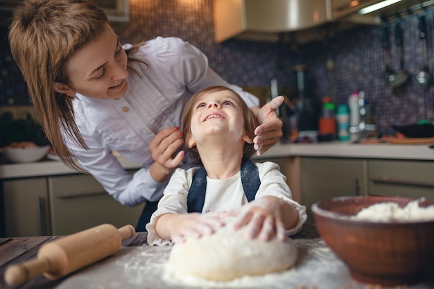 Meisje met kort haar kneden van deeg in de keuken