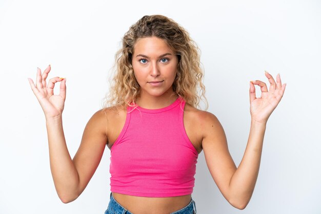 Meisje met krullend haar geïsoleerd op een witte achtergrond in zen pose