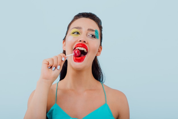 meisje met kunstzinnige make-up likt een lolly