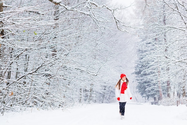 Meisje met lang haar in winterkleren wandelen in een park