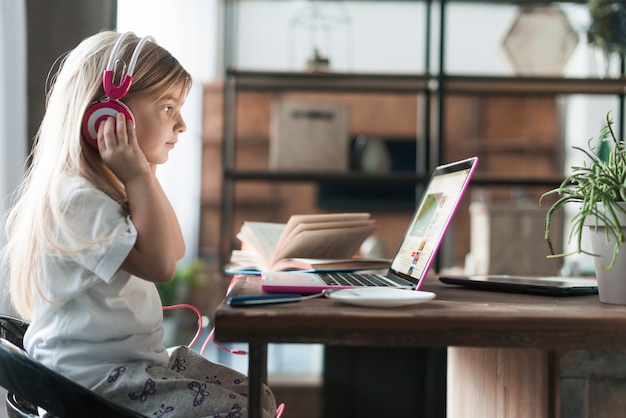 Foto meisje met laptop en hoofdtelefoons