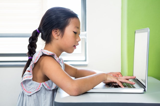 Meisje met laptop in de klas