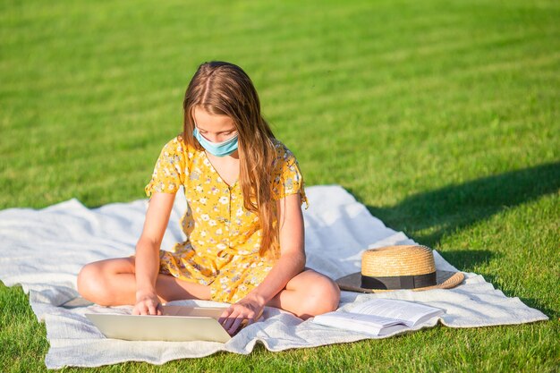 Meisje met laptop om buiten in het park te studeren