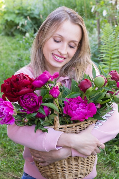 Meisje met mand met pioenrozen