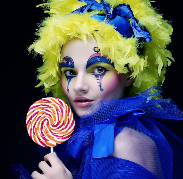 Meisje met met creatieve make-up houdt lolly