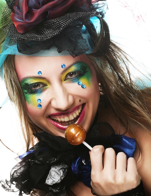 Meisje met met creatieve make-up houdt lolly