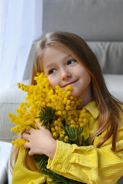 Meisje met mimosa op een witte achtergrond