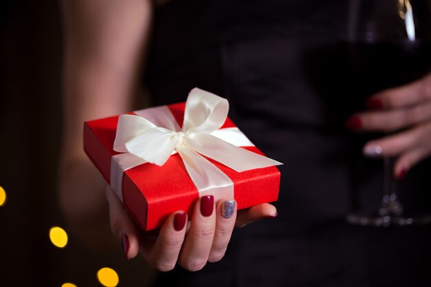 Meisje met mooi cadeau voor de dag van valentijnsdag. rode doos en witte boog en bokeh op de achtergrond