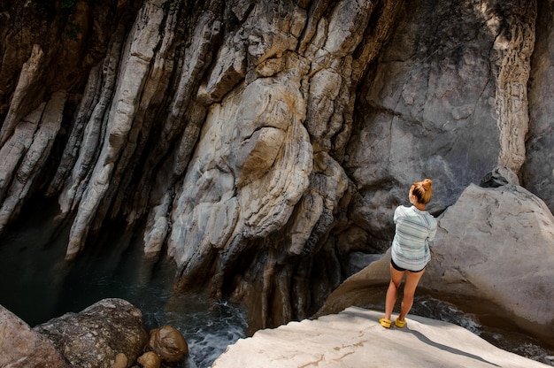 Meisje met paardestaart die zich dichtbij waterval in canion bevinden