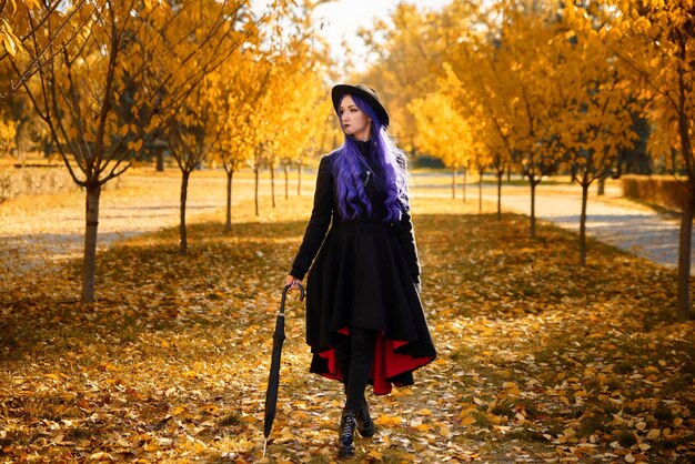 Meisje met paars haar in de herfst in het park