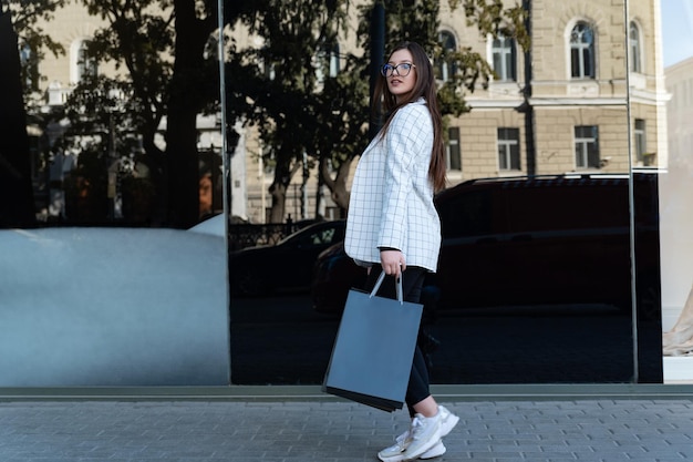 Meisje met pakket na succesvol winkelen. Gelukkig mooie jonge vrouw met aankopen. Black Friday-kortingen.