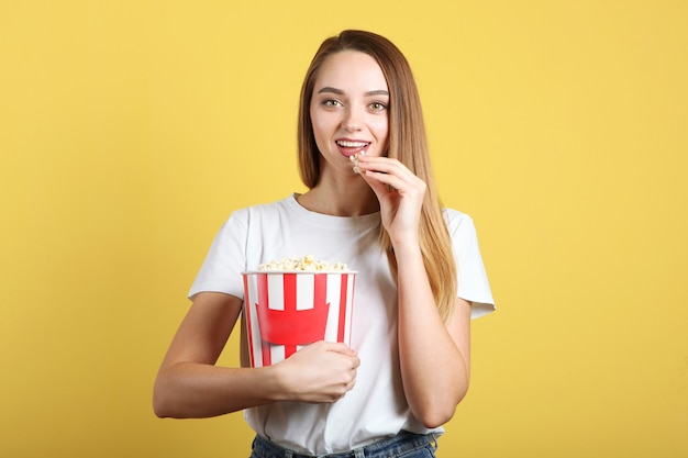 Meisje met popcorn op een gekleurde achtergrond kijken naar een film d film