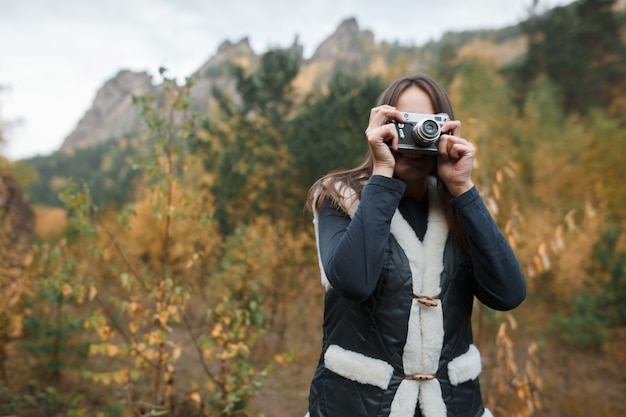 Meisje met retro camera in de herfst bergen