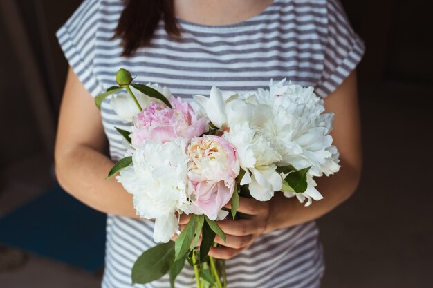 Meisje met roze en wit pioenenboeket