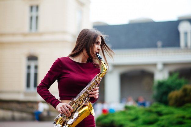 Meisje met saxofoon spelen op straat