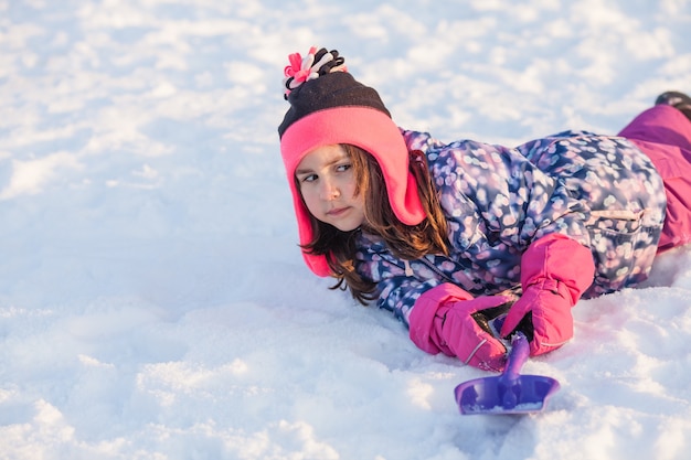 Meisje met schop lag in de sneeuw