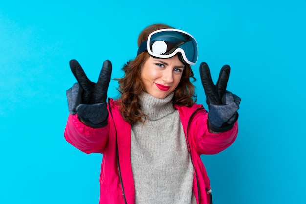 Foto meisje met sneeuwglazen over geïsoleerde muur