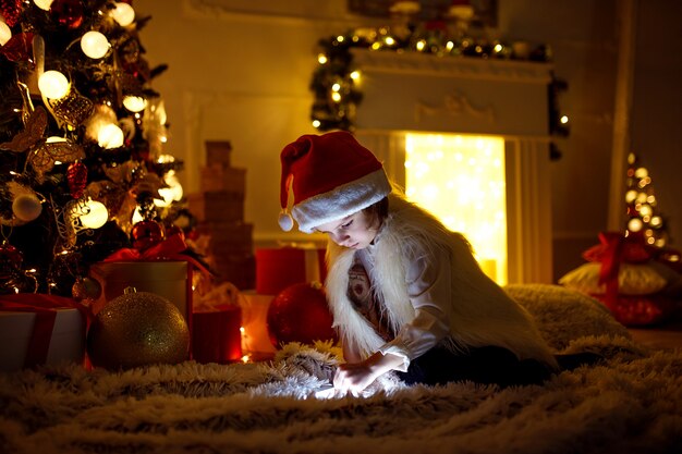 Meisje met tablet dichtbij Kerstboom