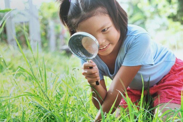 Meisje met vergrootglas in de natuur