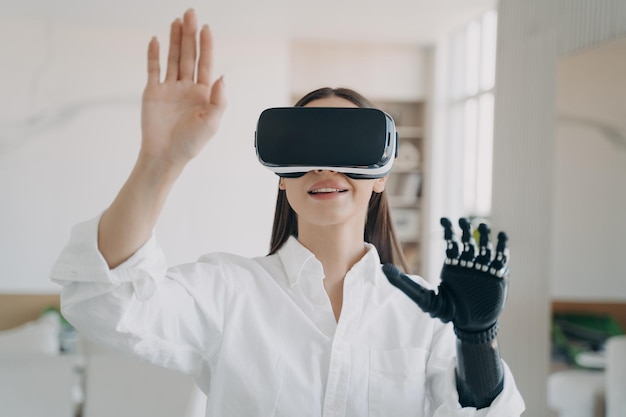 Meisje met VR-bril interageert met augmented reality raakt virtueel object aan door bionische prothetische arm