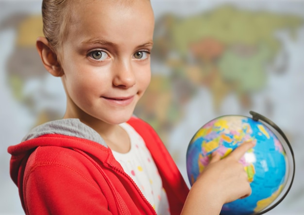 Meisje met wereldbol tegen wazige kaart