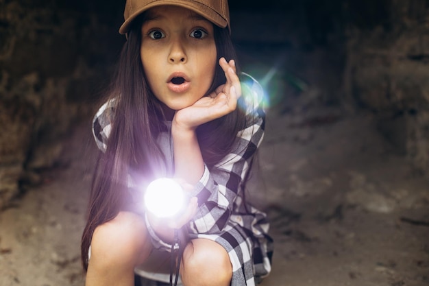 Meisje met zaklamp in grot op zoek naar oudheid