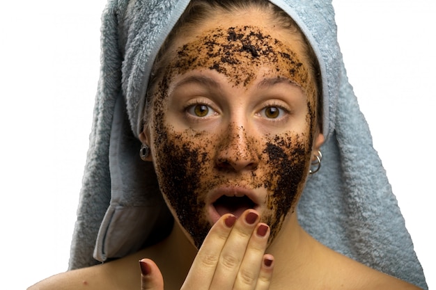 Meisje na douche met een handdoek en verschillende gezichtsuitdrukkingen, gezicht met zelfgemaakte koffieroom