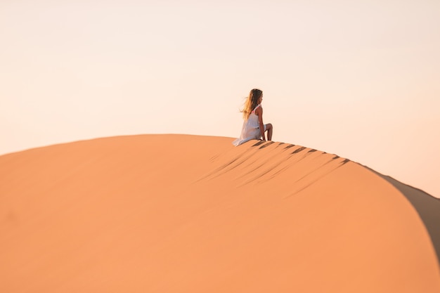 Meisje onder de duinen in de woestijn in de Verenigde Arabische Emiraten