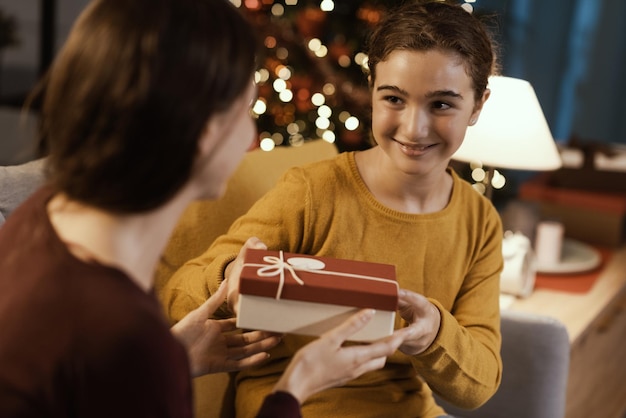 Meisje ontvangt een kerstcadeau van haar moeder