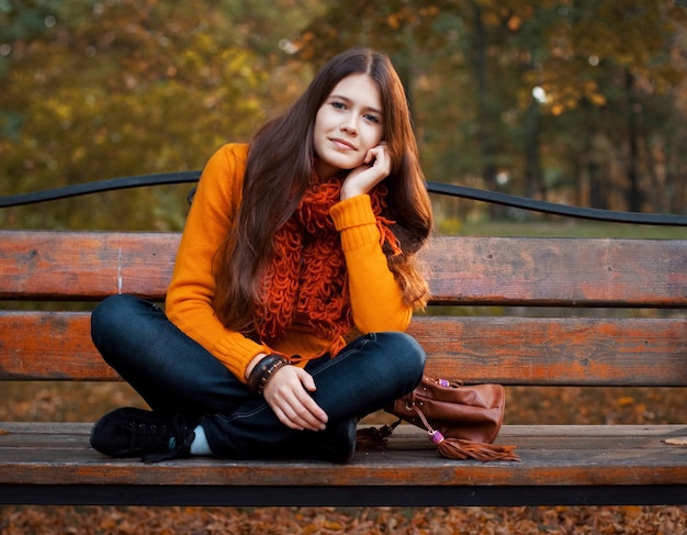 Meisje op bank in de herfstpark