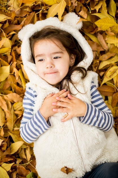 Meisje op de herfst bladeren