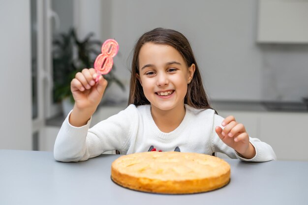 Meisje op de verjaardag met een taart met kaars