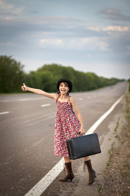 Meisje op de weg met oude koffer stopte auto