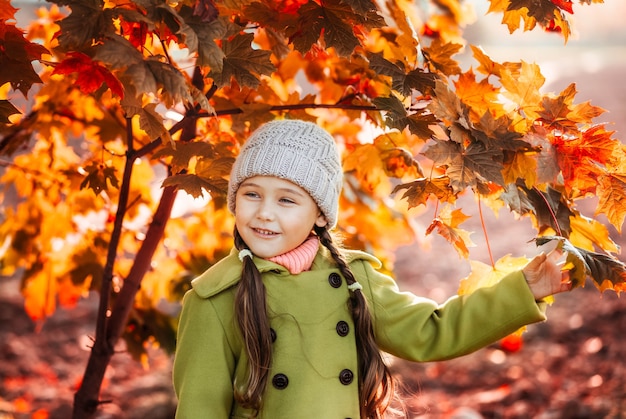 Meisje op een achtergrond van oranje herfstbladeren. Herfst portret