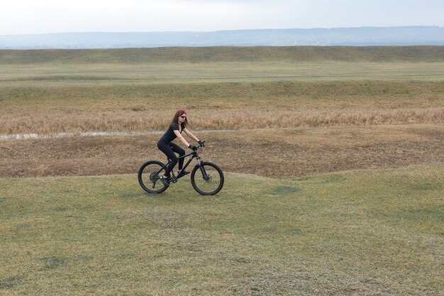 Meisje op een mountainbike op offroad mooi portret van een fietser bij regenachtig weer