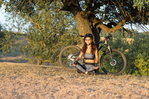 Meisje op een mountainbike op offroad mooi portret van een fietser bij zonsondergang